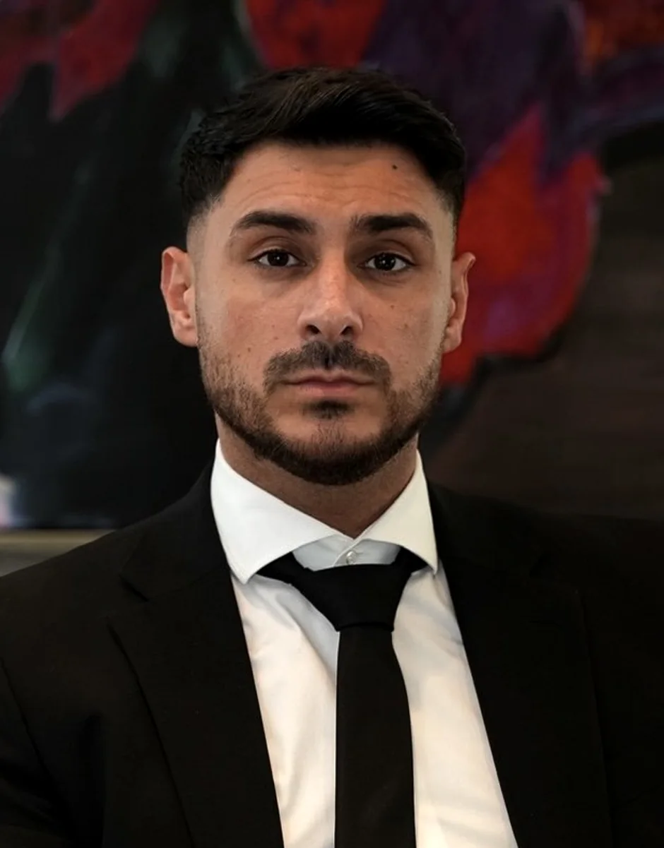 Yousif Sakmany, Gründer von NEXUS, vor einem violetten Kunstgemälde