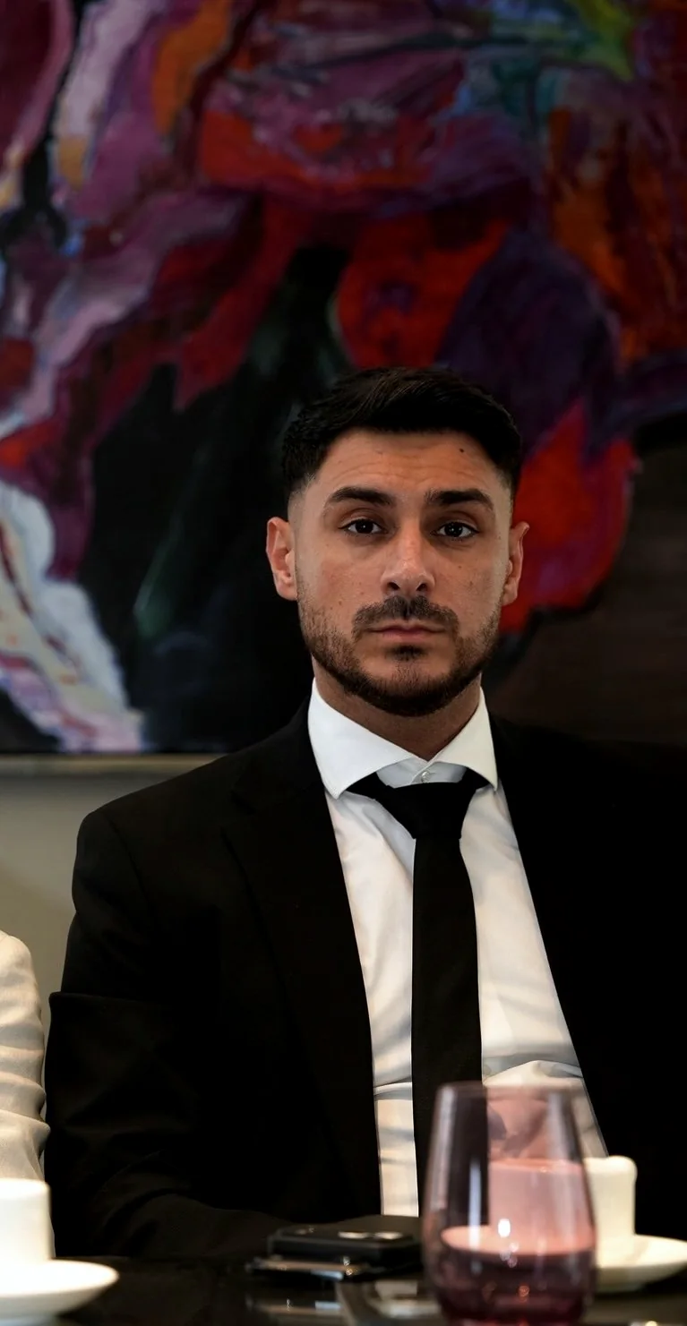 Yousif Sakmany, Gründer von NEXUS, vor einem violetten Kunstgemälde